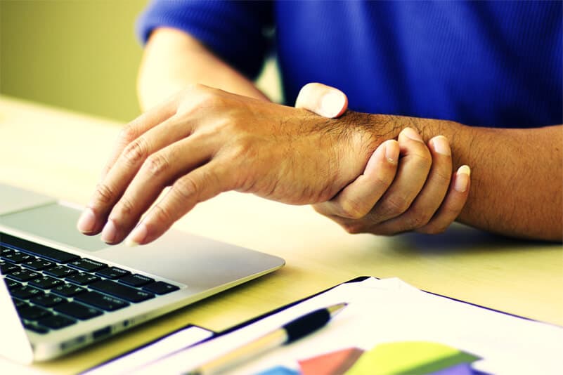 Caucasian person in blue sweater experiencing wrist pain