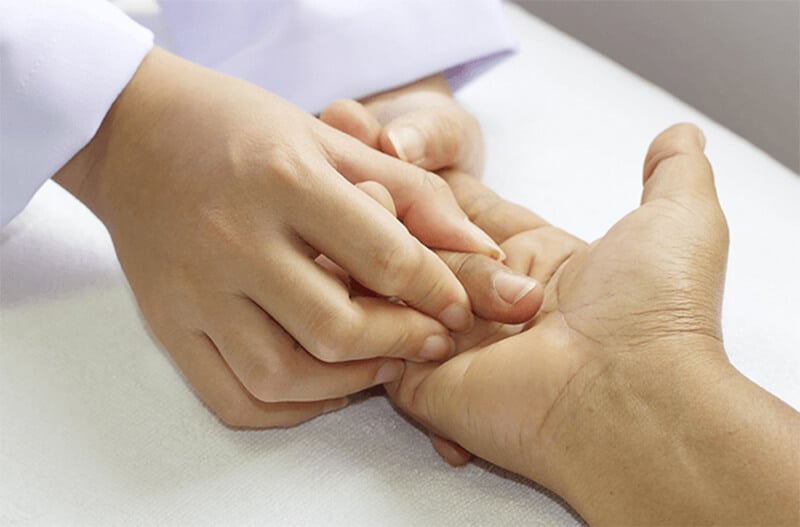 A hand therapist performing manual hands-on physical therapy